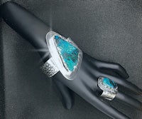 a mannequin with a turquoise stone ring and cuff