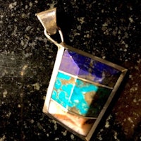 a sterling silver pendant with a blue and turquoise stone