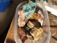 a container full of different colored rocks sitting on top of a table