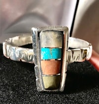 a silver ring with a multi colored stone